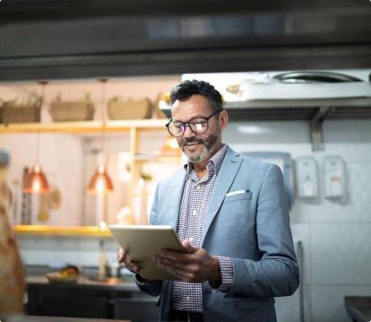 Man in a suit looking at a restaurant POS system on a table