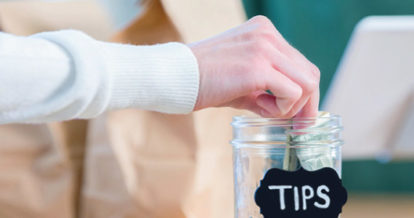 A customer putting money in the tip jar.