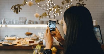 A person taking a photo of food with their phone