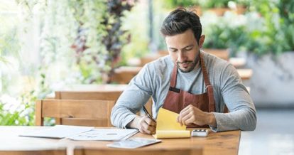 Restaurant employee calculating metrics at a restaurant table