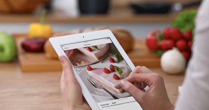 Image of restaurant worker looking at a iPad with a restaurant menu item