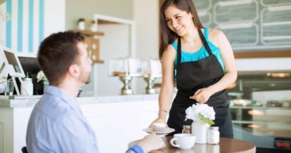 Waitress serving a dessert to a customer at a cafe