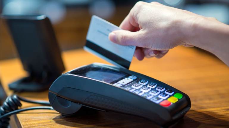 A customer swiping a card at a payment terminal