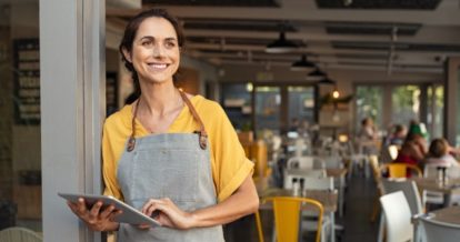 restaurant owner at doorway with POS in hand