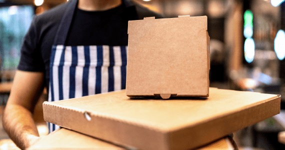 Server preparing food in take out boxes for delivery