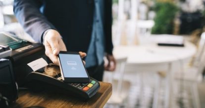 Customer paying with contactless payment on his phone