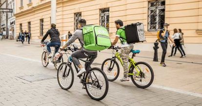 Three cyclists riding their bikes to deliver food