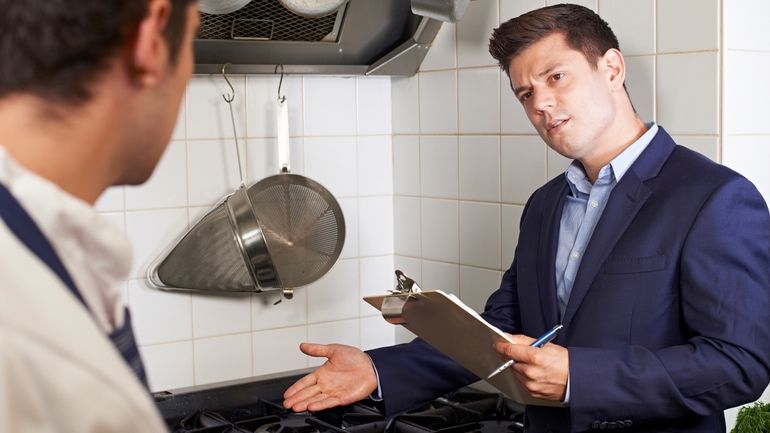 A health inspector meeting with a chef in a restaurant