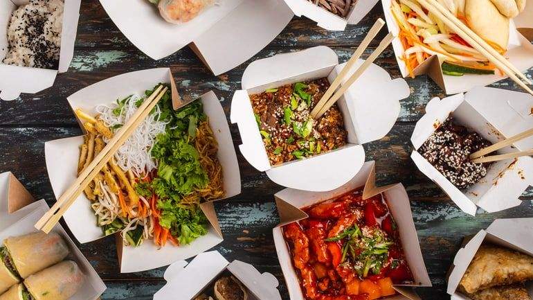 Birds eye view of colourful cuisine in takeaway boxes