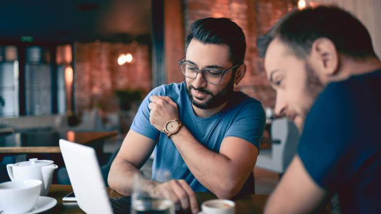 Two men reading negative reviews on a laptop