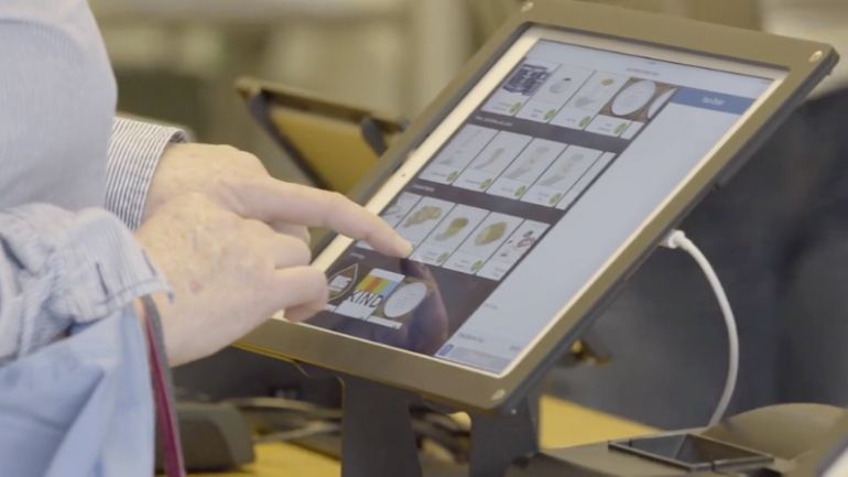 Person ordering from a self-ordering iPad kiosk