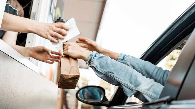 Customer receiving a receipt and ordered food at drive-thru