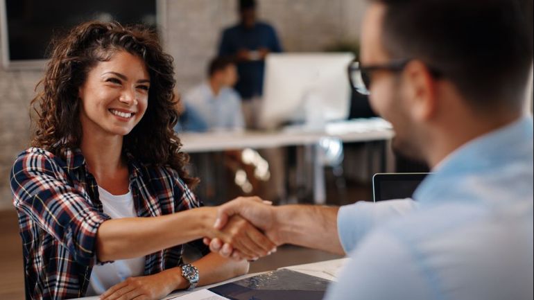 Restaurant owner shaking hands with employee