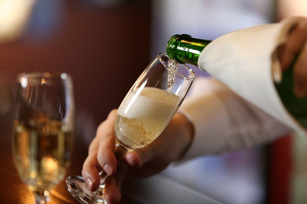 Bartender pouring a glass of sparkling wine