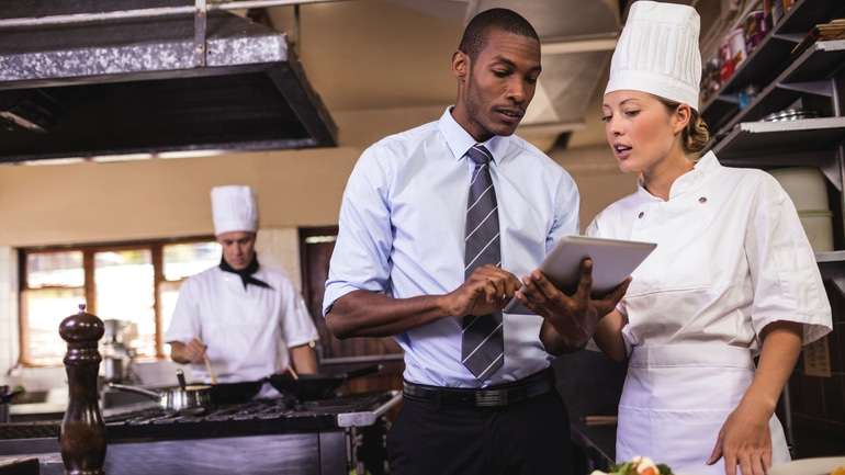 Restaurant manager speaking with chef