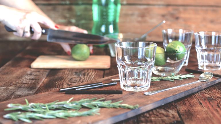 Barback prepping lime and rosemary garnish