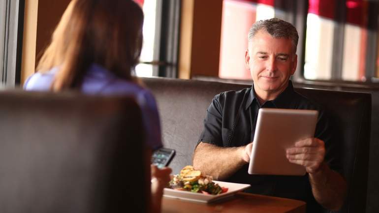 customers ordering on iPad kiosk at their table