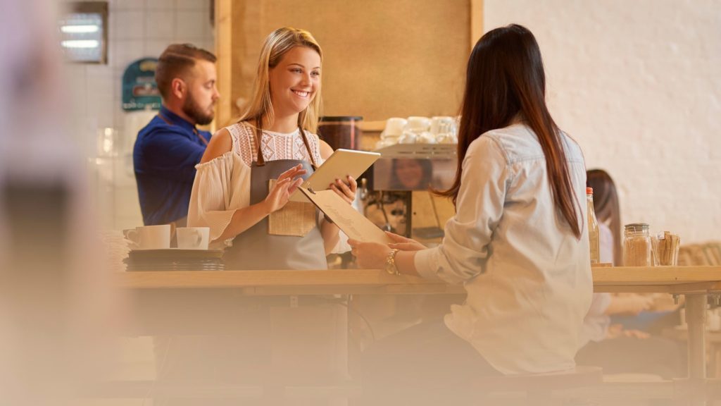 server taking order from cafe patron
