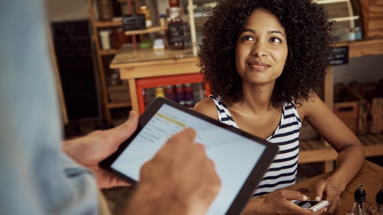 Waiter taking a customer's order in a restaurant using an iPad POS system