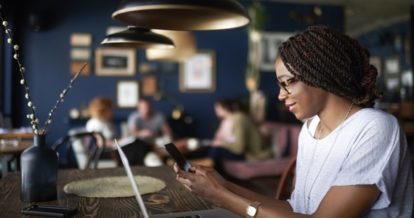 woman reads on her mobile phone in a restaurant