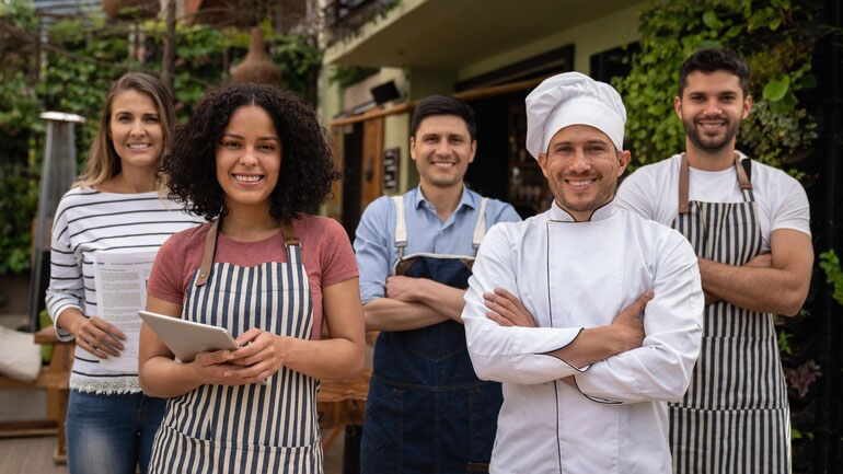 Restaurant employee team smiling and looking at the camera.