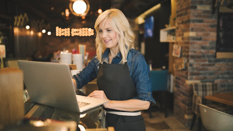 Coffee shop owner working on laptop