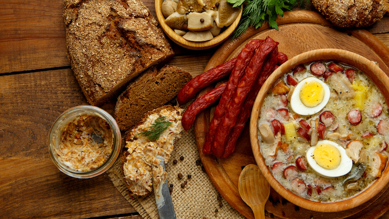 Traditional Zurek with sausage and egg, white borscht, and polish Easter soup displayed on a table.