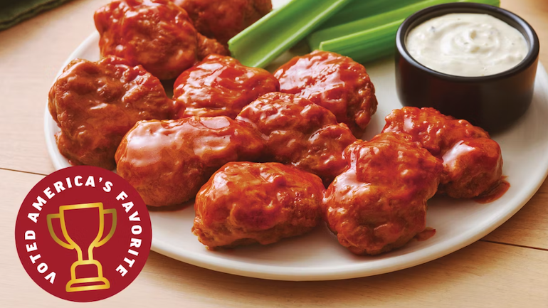 Plate of boneless wings with sauce and celery.