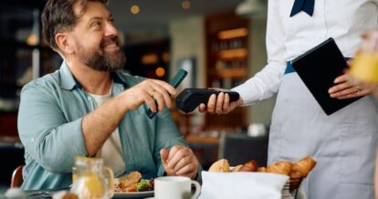 Man paying for his meal at a restaurant using his mobile device.