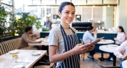 Female server using an iPad to take an order in a restaurant.